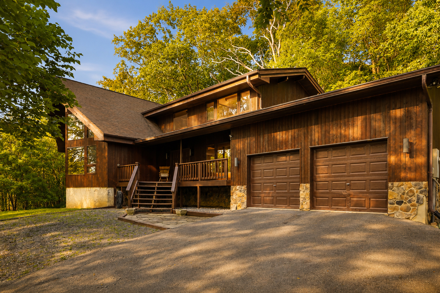 Wood cabin exterior with two-car garage at golden hour