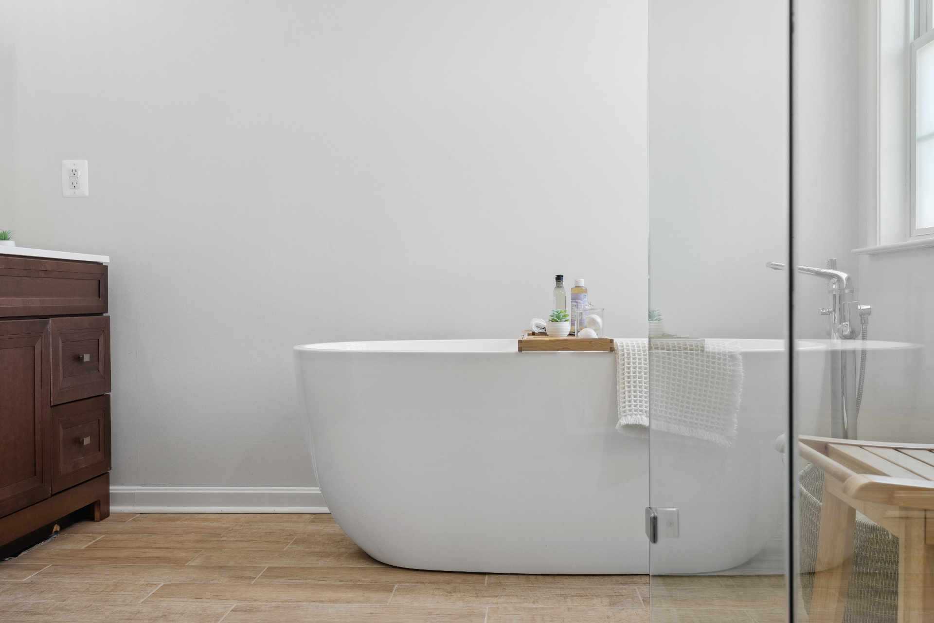 Minimal bathroom with freestanding soaking tub and glass shower