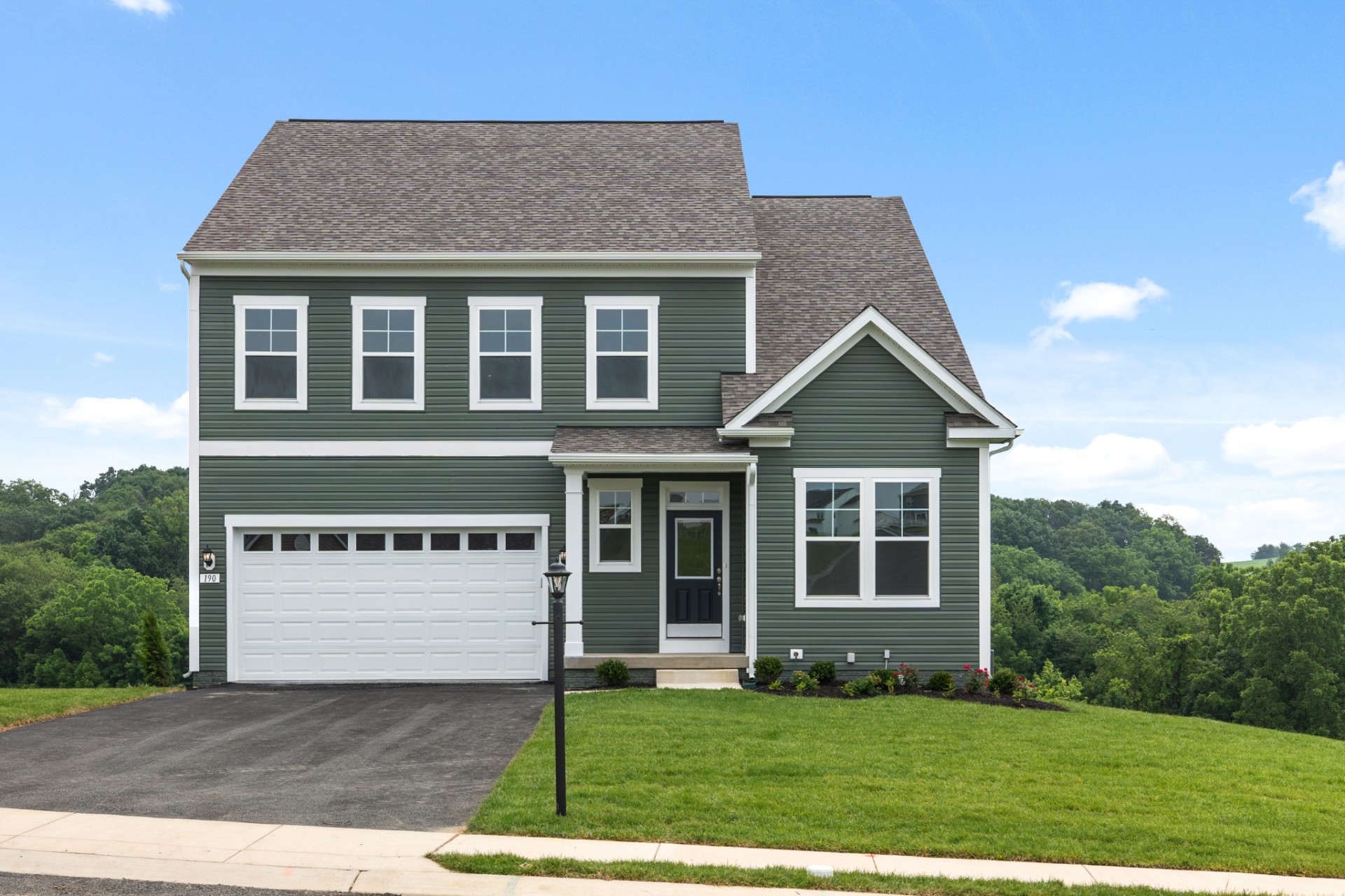 Green two-story suburban home with white trim